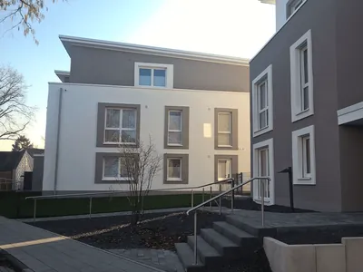 Zwei Mehrfamilienhäuser mit weißem und grauem Putz, Außentreppe mit Edelstahlgeländer. Mönchengladbach, Nespeler Straße (Großansicht)